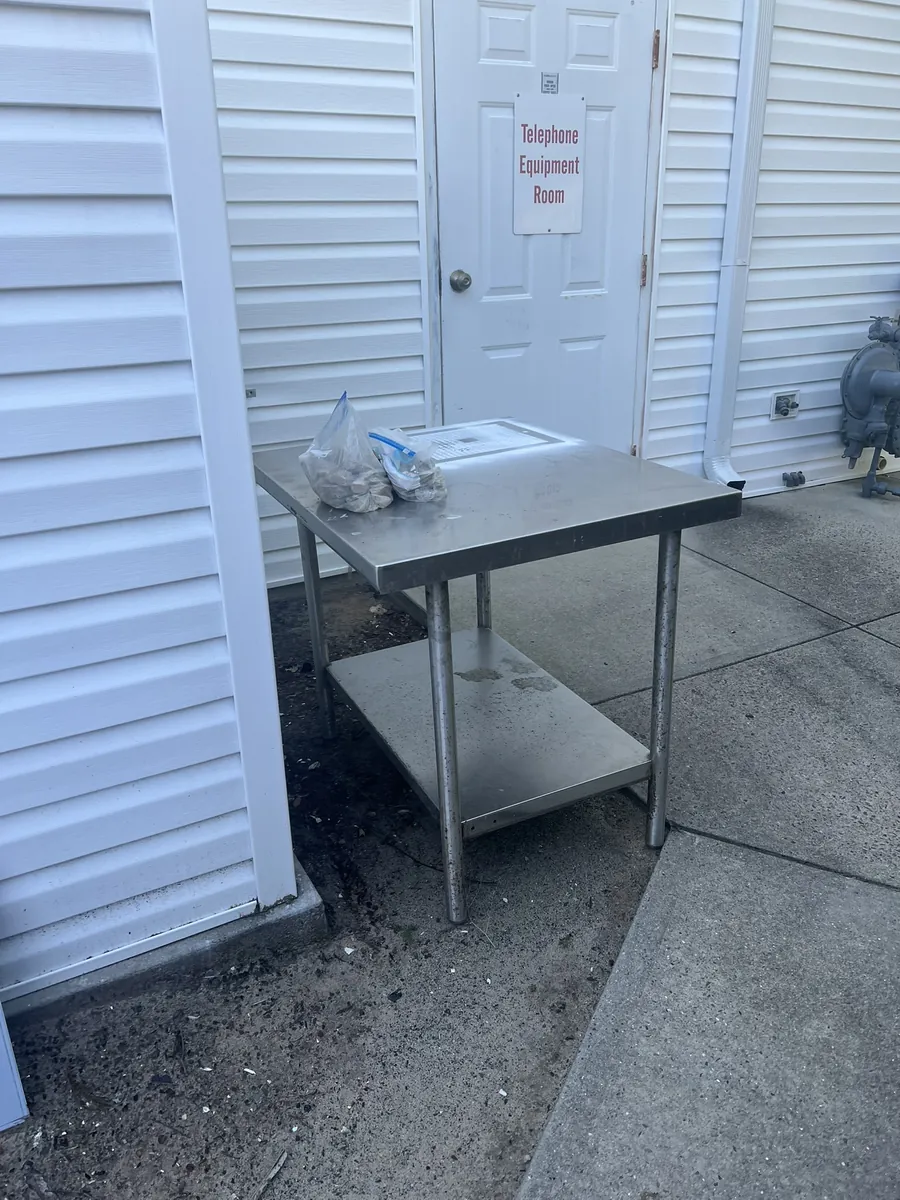 A stainless steel prep table set out by a back door