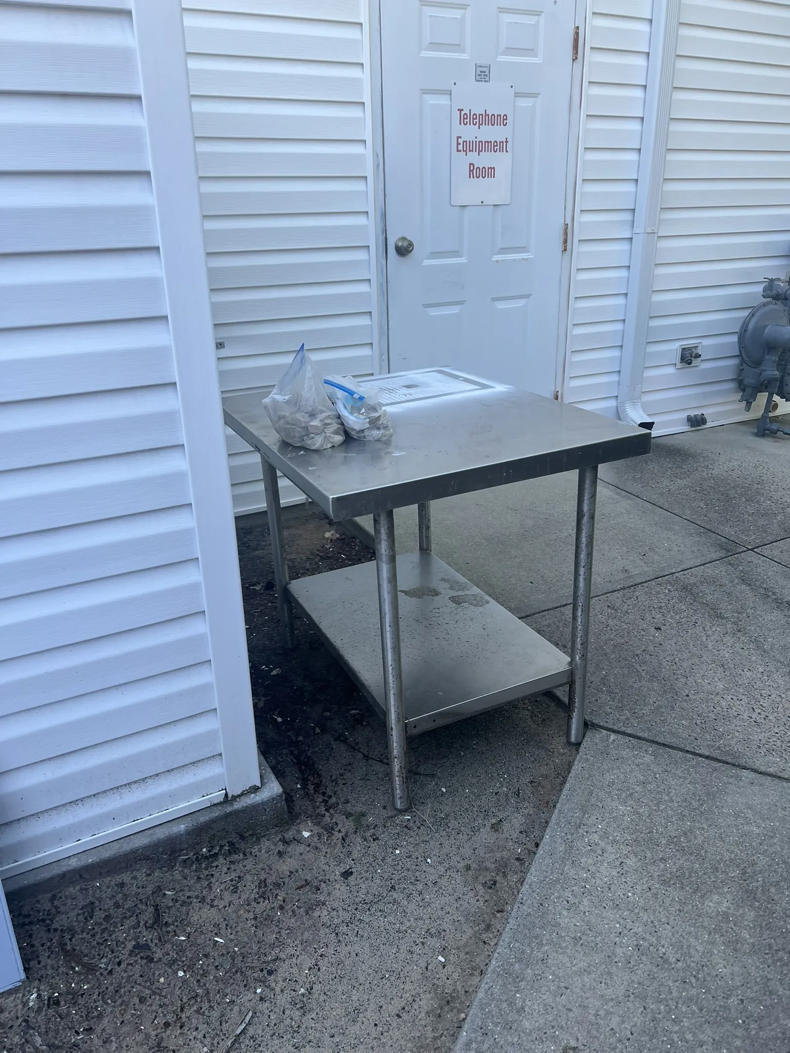 A stainless steel prep table set out by a back door