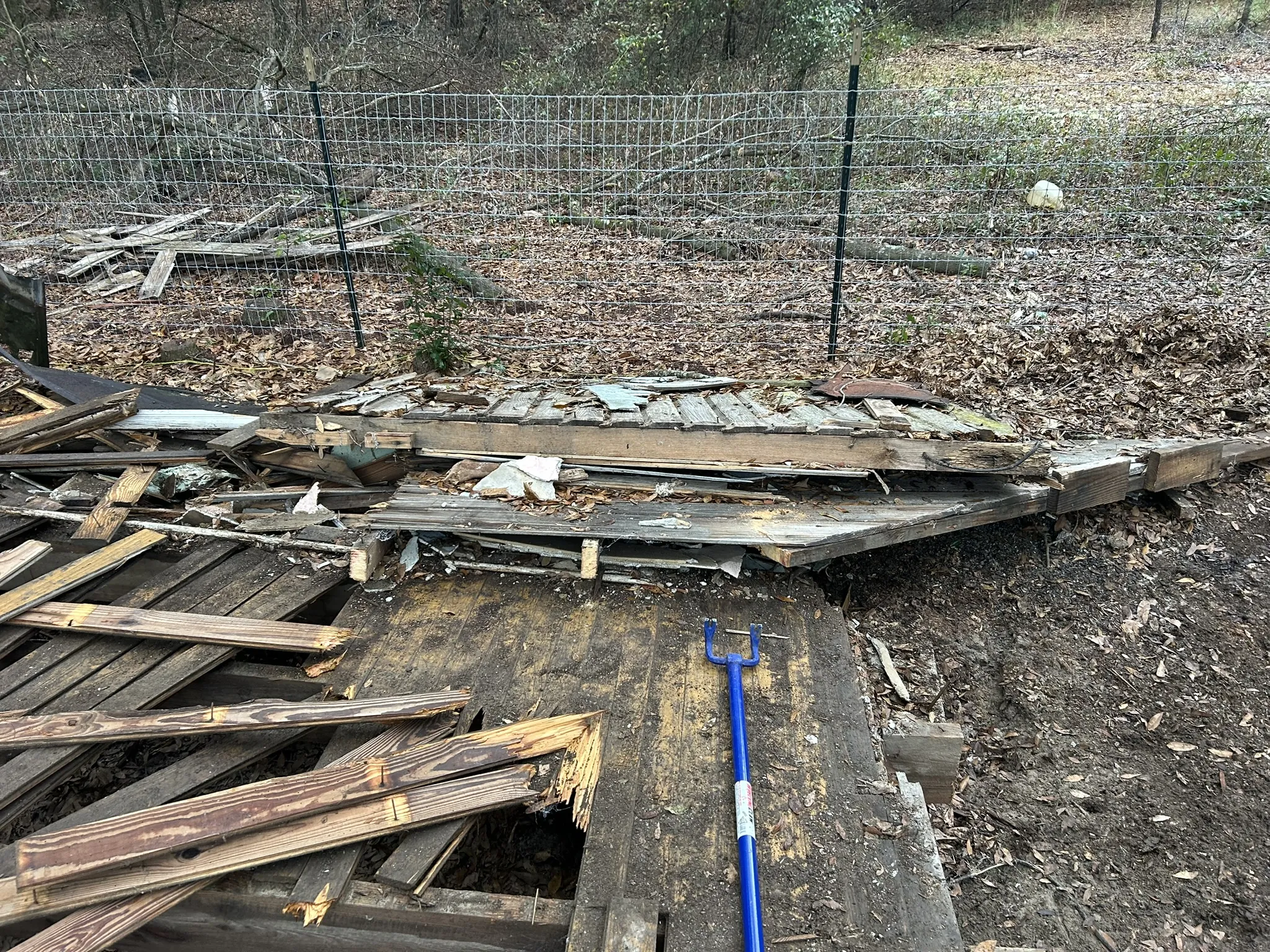 Broken deck boards and lumber spread across a yard