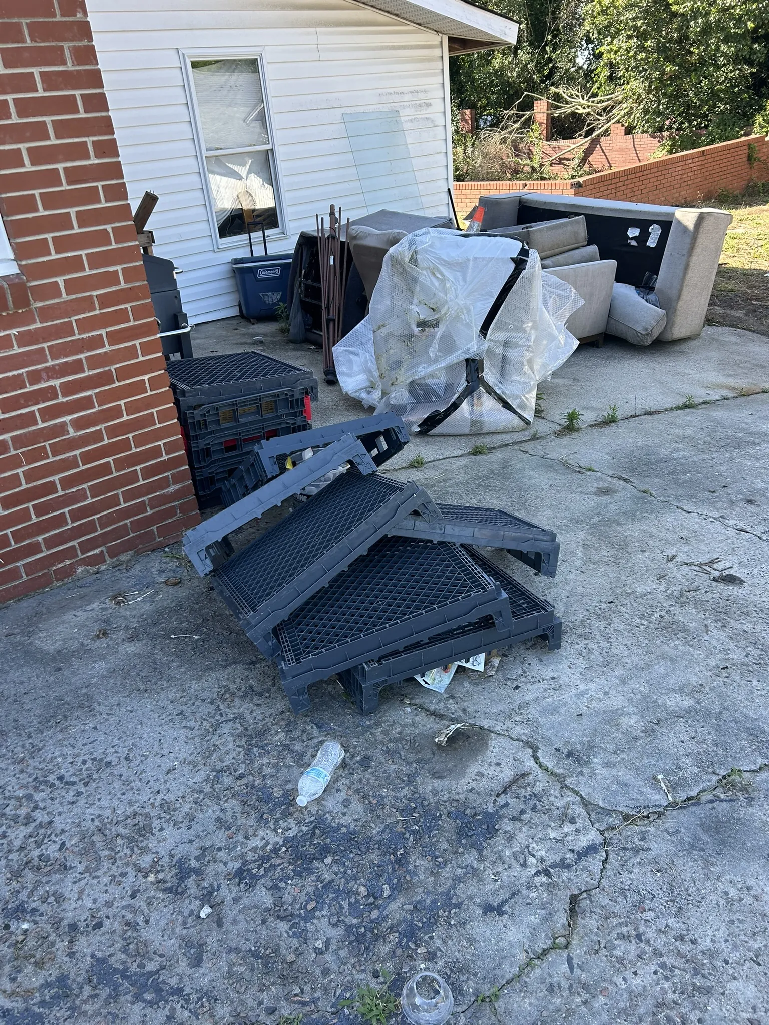 Broken furniture and chairs piled in a carport