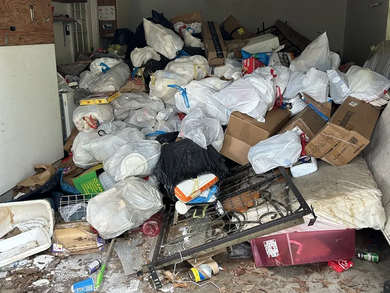 A two-car garage packed with bags, boxes and a bed frame