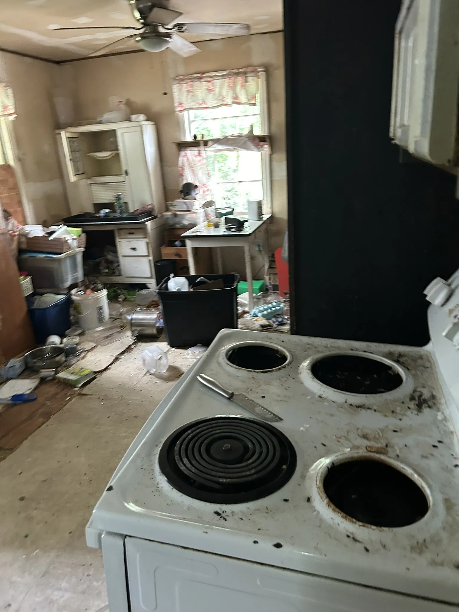 A cluttered kitchen with an old electric stove