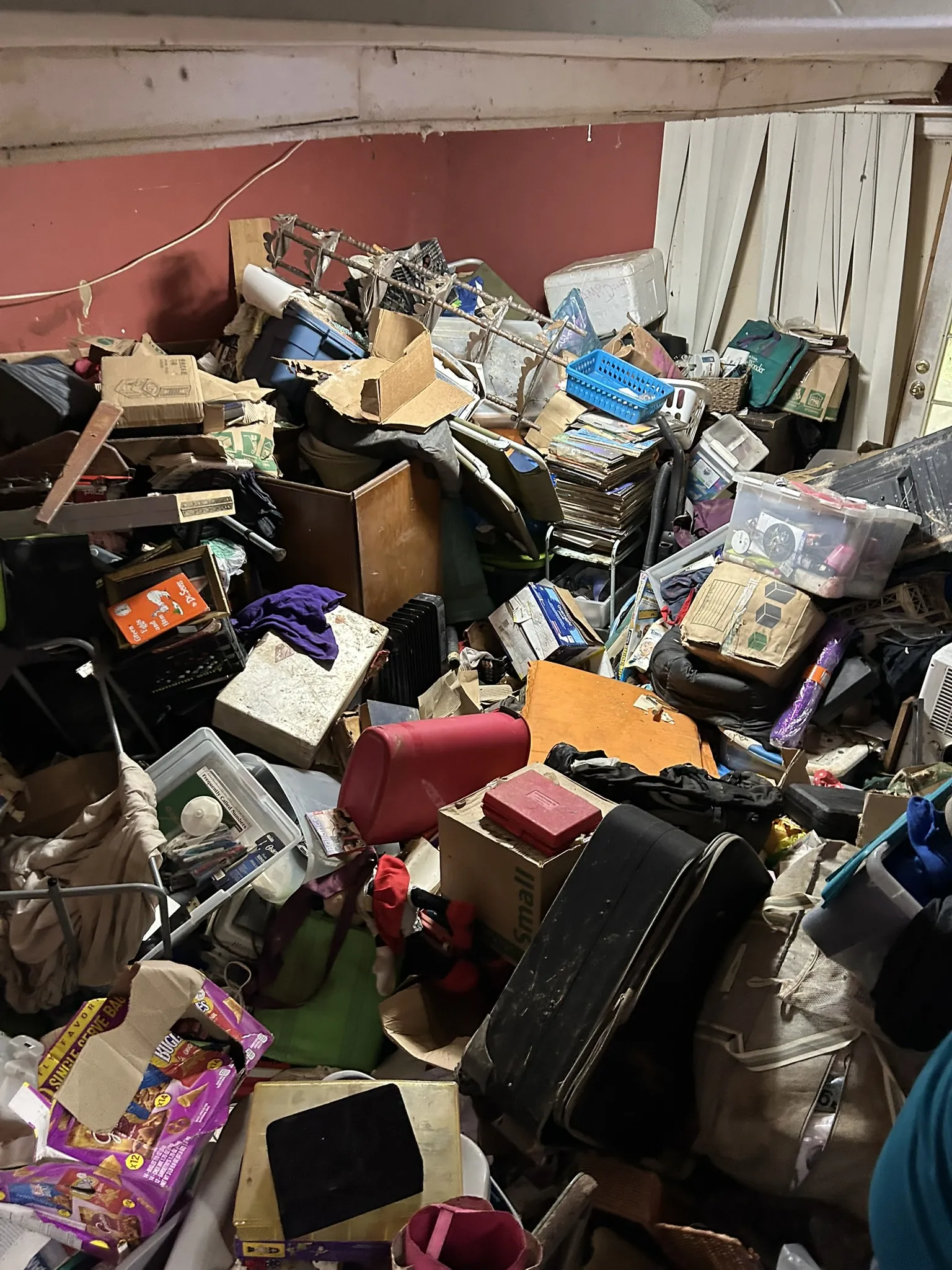 A room packed floor to ceiling with boxes, bins and belongings
