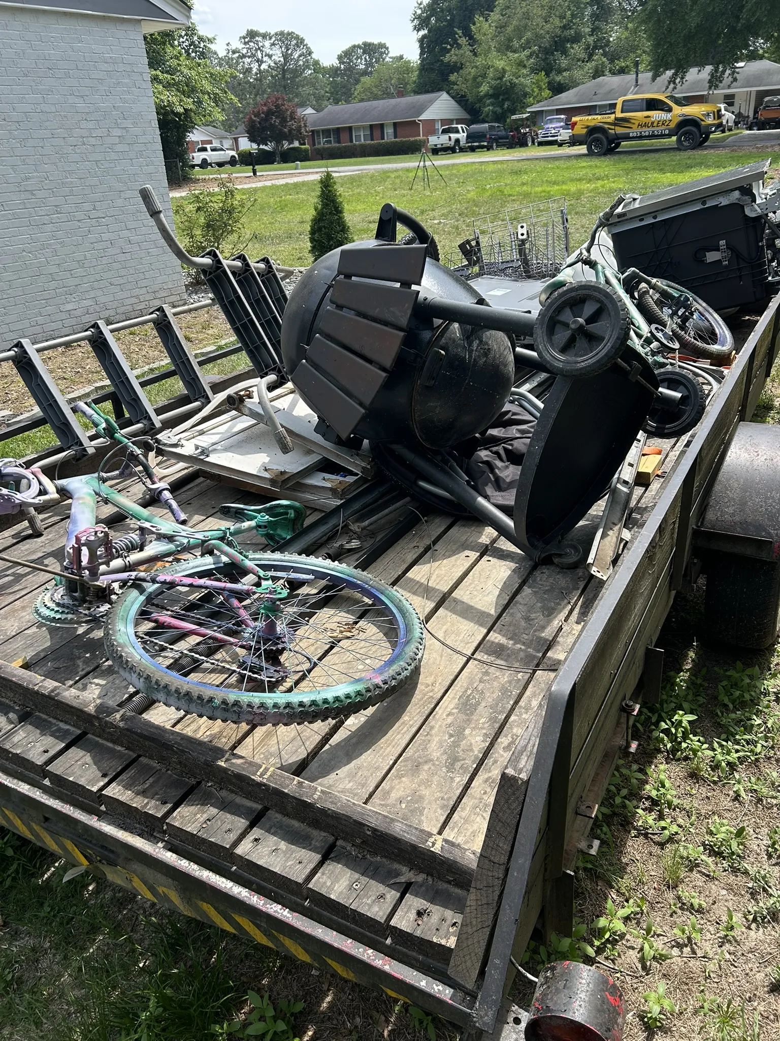 Bikes, chairs and household items loaded on a flatbed trailer