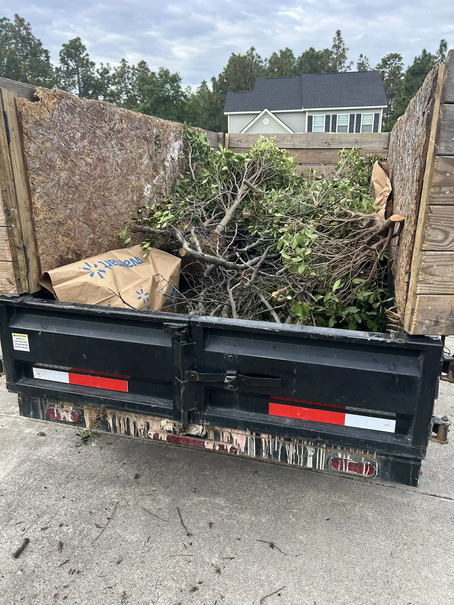 The dump trailer loaded with branches and brush