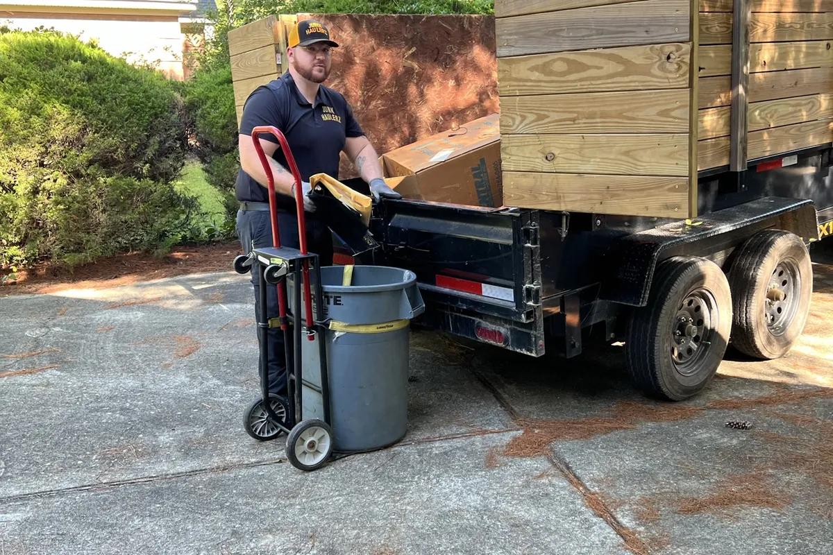 Pat Boatwright wheeling items to his dump trailer on a hand truck