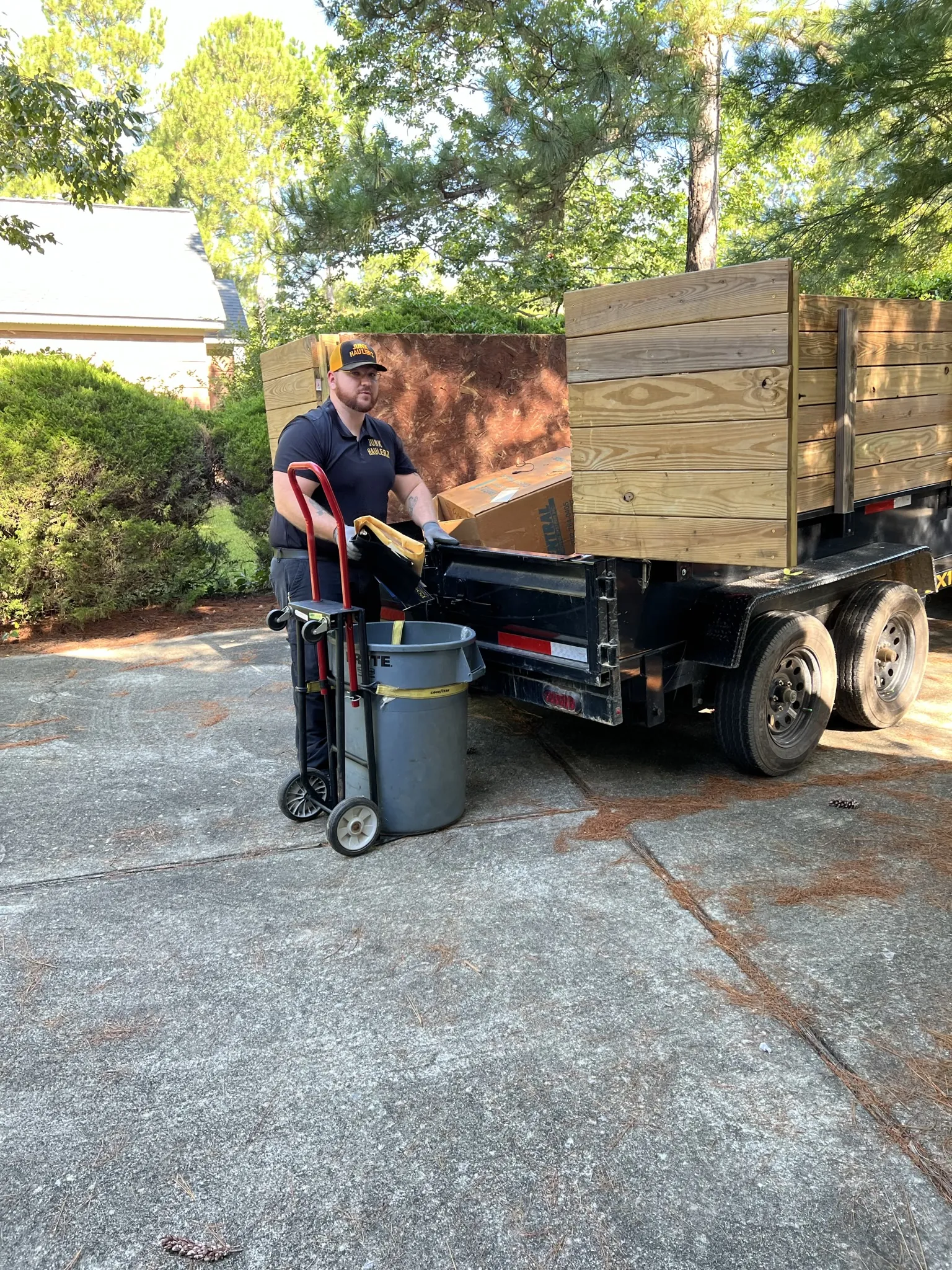 Pat Boatwright wheeling items to his dump trailer on a hand truck