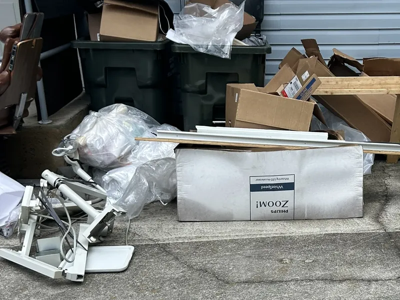 Dental office equipment, boxes and bins set out beside an office building