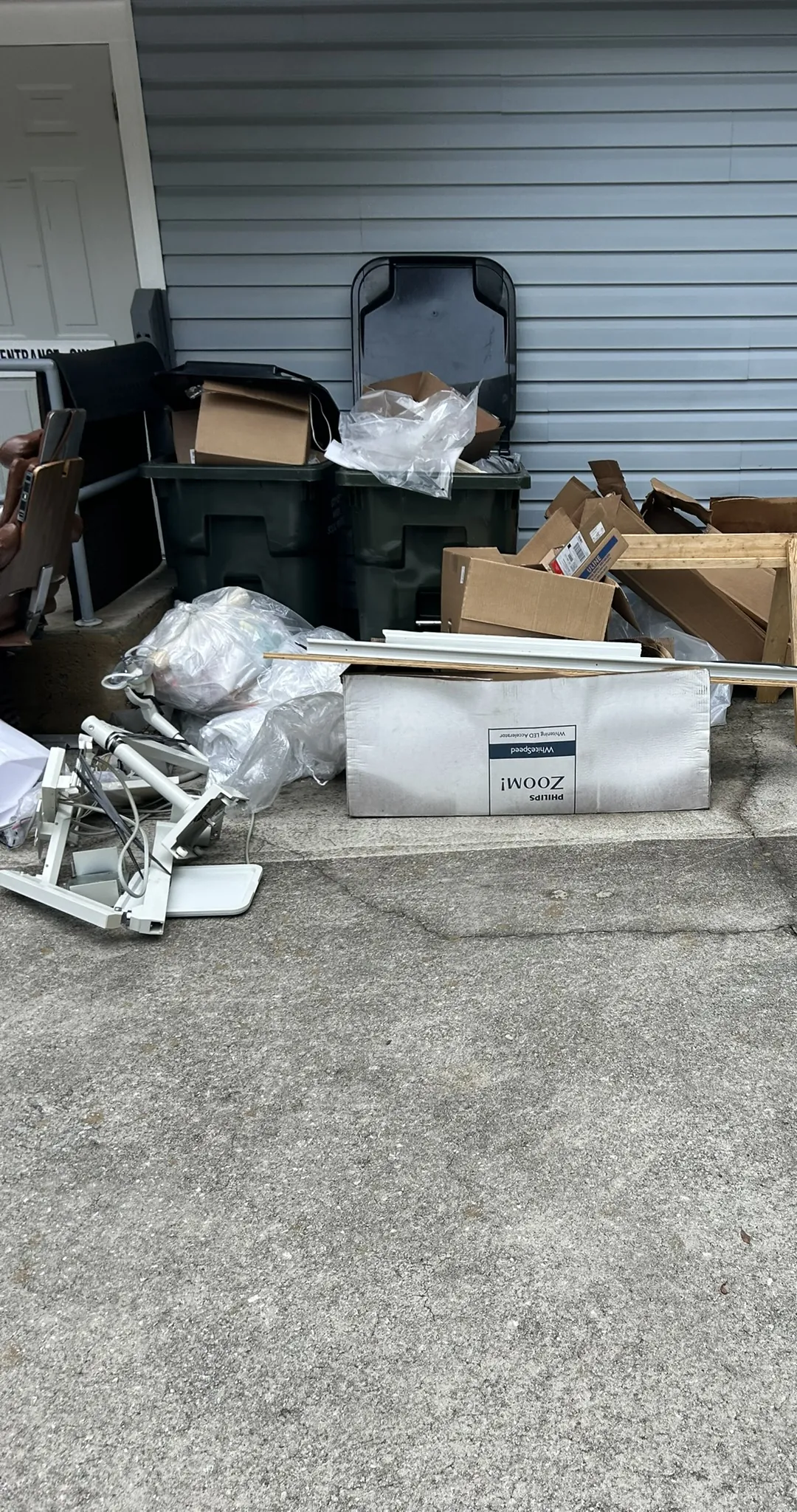 Dental office equipment, boxes and bins set out beside an office building