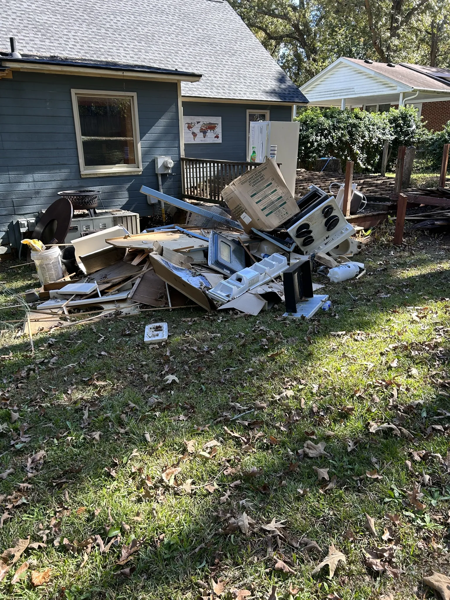 A pile of boards, panels and household items in a backyard