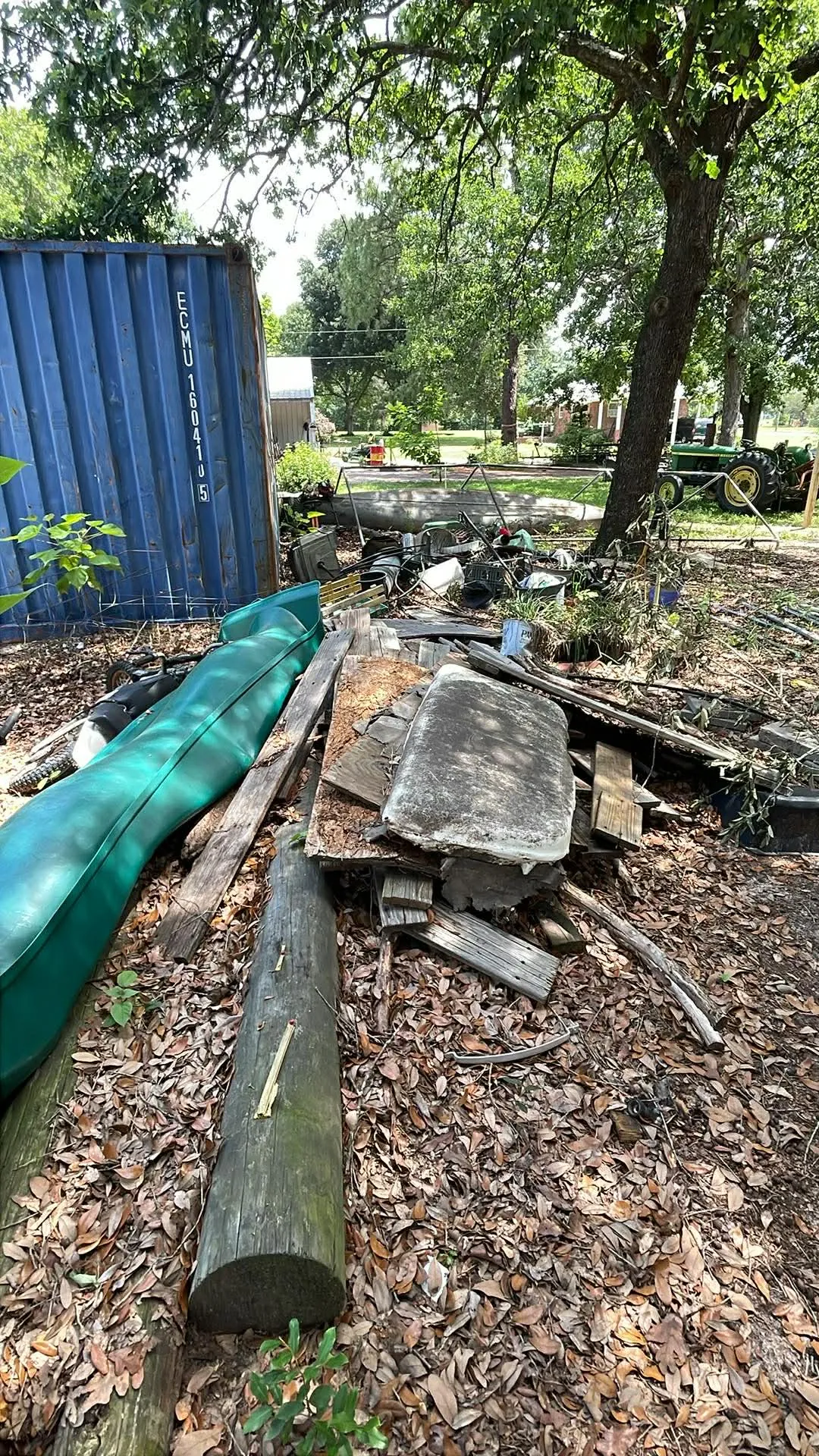 Logs and boards piled along a shipping container