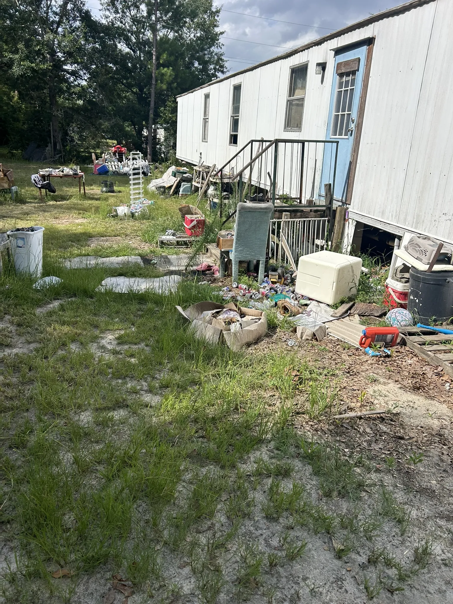 Household items scattered in the yard of a mobile home