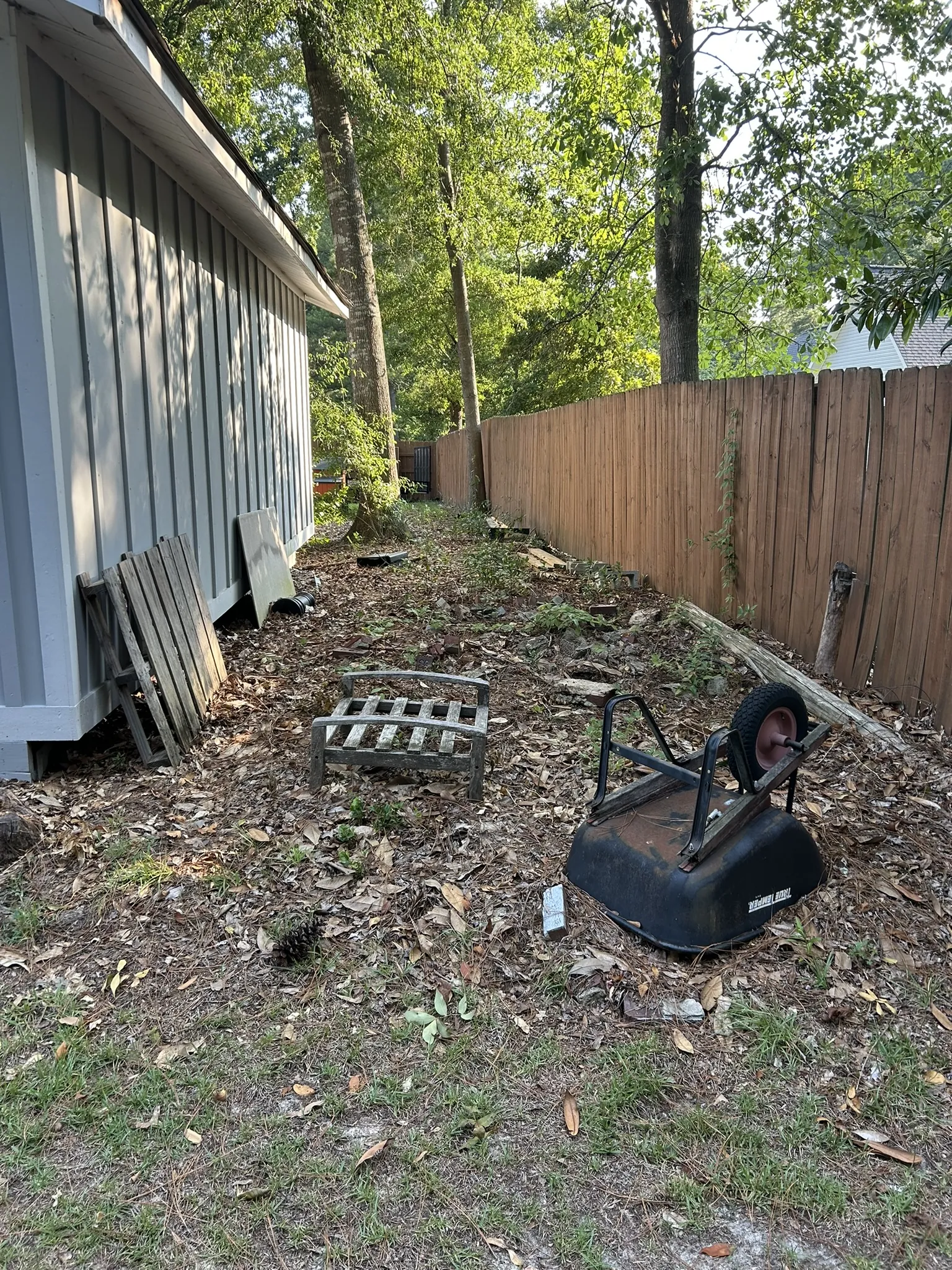 Old chairs and panels left along the side of a house